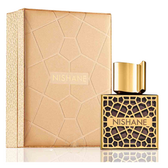 Nishane perfume bottle with dark liquid and gold geometric pattern alongside its matching gold box, all on a reflective white surface