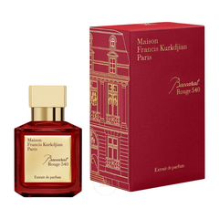Maison Francis Kurkdjian Baccarat Rouge 540 perfume bottle and box, showcasing the deep ruby red hexagonal bottle with gold cap and label, next to a vibrant red box featuring a detailed gold line art illustration of a classic Parisian Haussmann building facade