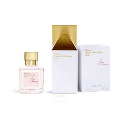 Maison Francis Kurkdjian Paris L'eau À la rose Eau de toilette product photograph featuring a square clear glass bottle with pale pink liquid and a gleaming gold cap next to its open white box revealing a metallic gold interior and the product name in elegant pink script