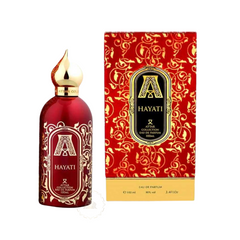 Product image of Attar Collection Hayati perfume bottle and its box featuring a rich red and gold color scheme with intricate arabesque patterns a distinctive gold genie-lamp shaped cap and 100ml Eau de Parfum labeling