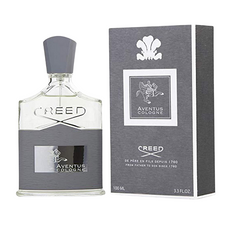 Product photography of a Creed Aventus Cologne clear glass bottle with a grey textured label and matching cap, presented next to its grey box featuring a white horse and rider motif and "100 ML 3.3 FL. OZ." text