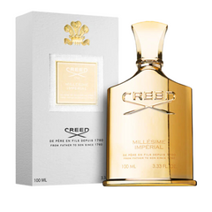 Product photograph of the Creed Millésime Impérial perfume, featuring a shiny gold bottle and a white box, both marked with the gold Creed logo and "De Père en Fils Depuis 1760" text
