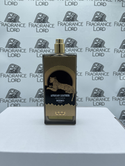 Photograph of a Memo Paris African Leather Eau de Parfum bottle, matte black with a gold top and accents, featuring a spotted leopard illustration and zigzag patterns, displayed on a white surface against a repeated Fragrance Lord logo background