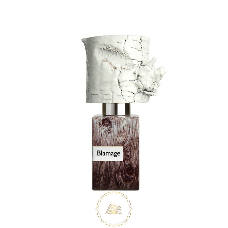 A distinctive perfume bottle featuring a textured white birch bark-like cap, a dark brown wood grain body with a Blamage label, and a golden circular brand logo below