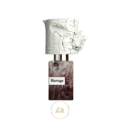 A distinctive perfume bottle featuring a textured white birch bark-like cap, a dark brown wood grain body with a Blamage label, and a golden circular brand logo below