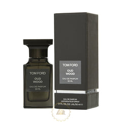 Product photography of a Tom Ford Oud Wood Eau de Parfum 50ml dark rectangular bottle with a ridged cap and its matching textured box displaying prominent white text