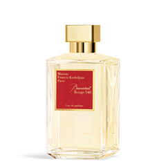Product photography by Maison Francis Kurkdjian of a Baccarat Rouge 540 Eau de parfum bottle from Paris, featuring a clear rectangular glass bottle, shiny gold cap, and a prominent red label with elegant gold lettering