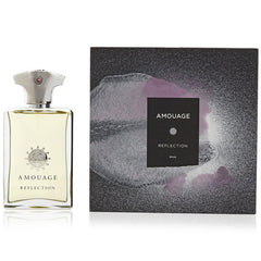 Product image by Amouage of the Reflection Man perfume set featuring a clear rectangular bottle with a silver cap and pink gem alongside a dark gray speckled box adorned with abstract purple swirls and the prominent Amouage Reflection Man label