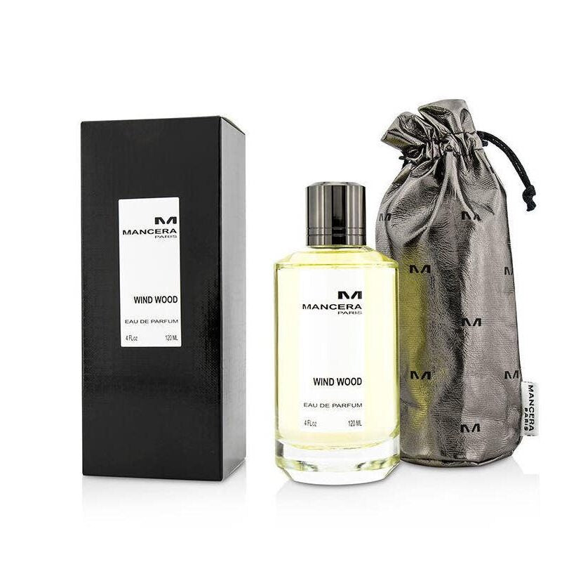 Mancera Paris Wind Wood Eau de Parfum 120ml in a clear glass bottle with light yellow liquid and dark metallic cap, accompanied by its black rectangular box and a shimmering silver drawstring pouch with embossed M logos