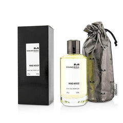 Mancera Paris Wind Wood Eau de Parfum 120ml in a clear glass bottle with light yellow liquid and dark metallic cap, accompanied by its black rectangular box and a shimmering silver drawstring pouch with embossed M logos
