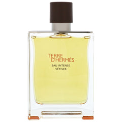 Hermès Terre d'Hermès Eau Intense Vétiver fragrance bottle in clear rectangular glass containing yellowish-green liquid with a dark brown square cap and red text on a white background