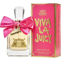 Product photography Juicy Couture Viva La Juicy perfume bottle and box displaying a clear bottle with gold liquid a vivid fuchsia bow with a dangling gold Couture charm and the brand's signature gold crown crest on the bottle and pink packaging