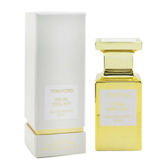Product photograph of Tom Ford Soleil Brûlant Eau de Parfum featuring a bright gold rectangular bottle next to its textured white box, both displaying the name in elegant gold text and a 50ml size