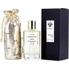 Product photo of Mancera Paris Precious Oud fragrance featuring a clear bottle with a metallic gold cap, a matching shiny gold drawstring pouch with repeated 'M' logos, and its black retail box with brand insignia