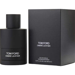 Product photo of Tom Ford Ombré Leather Eau de Parfum featuring a matte black cylindrical bottle with white text label next to a textured black rectangular box displaying brand and volume information