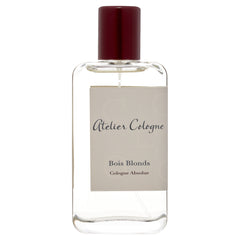 Product photography of an Atelier Cologne Bois Blonds Cologne Absolue perfume bottle, featuring a clear rectangular glass design, a dark red cylindrical cap, and a beige label with a subtle geometric pattern and elegant script text