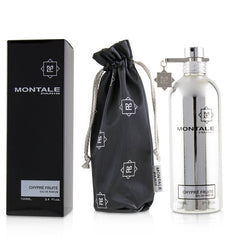 Montale Paris Chypre Fruité Eau de Parfum set displaying a sleek silver metallic bottle, a rectangular black presentation box, and a black drawstring pouch adorned with repeating Montale "M" logos and a silver "M" charm hanging from the bottle