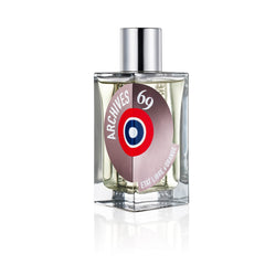 Etat Libre d'Orange Archives 69 perfume bottle on a white background, a clear square glass bottle with yellowish liquid, a silver cap, and a round beige label featuring "ARCHIVES 69" and a prominent red white and blue target graphic