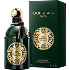 Guerlain Oud Essentiel Eau de Parfum in a dark green bottle with a gold spherical cap and a black and gold braided tassel alongside its matching box adorned with intricate gold ornamental labels