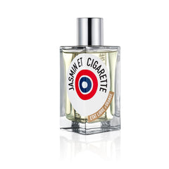 Product photo by Etat Libre d'Orange of a square clear glass Jasmin et Cigarette perfume bottle with a shiny silver cap, featuring a circular white label with the distinctive red, white, and blue bullseye target logo and a curved brown banner, presented on a white reflective studio background