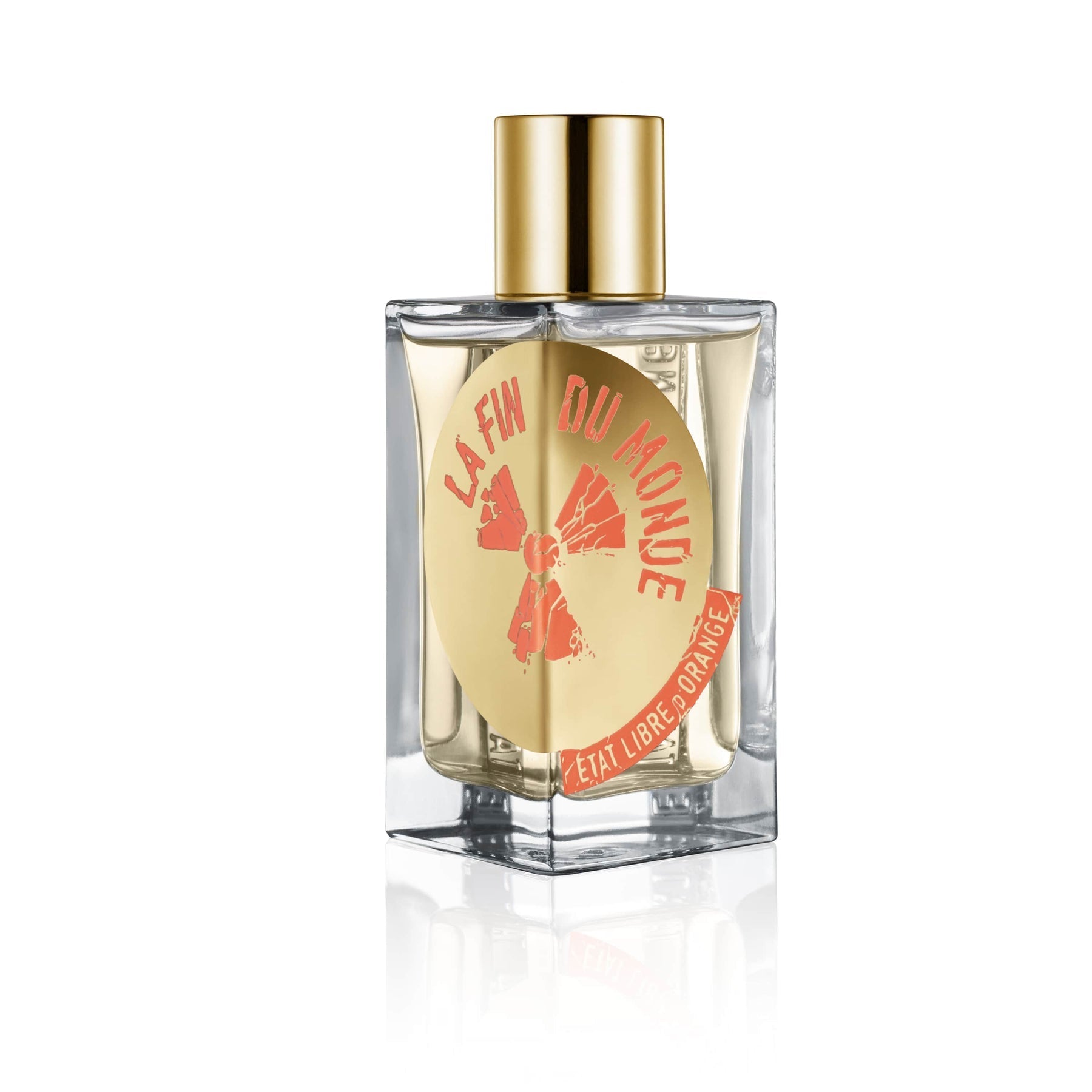 Product image of Etat Libre D'Orange La Fin Du Monde perfume in a clear rectangular glass bottle with a gold cap, showcasing a round gold label with coral 'La Fin Du Monde' text and an orange explosion graphic, accented by a red banner with 'Etat Libre D'Orange' lettering on a white reflective surface