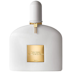 Product photography of a Tom Ford White Patchouli 100ml perfume bottle featuring a distinctive white ribbed design, a prominent gold label with the fragrance name, and a gold braided cord detailed with a 'TF' charm