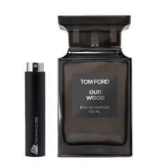 Photography of a dark grey Tom Ford Oud Wood Eau de Parfum 100 ML bottle alongside a black FragranceLord sample decant with a silver atomizer, presented on a minimalist white background