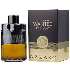 Azzaro Wanted by Night Eau de Parfum 100ml spray bottle with amber liquid in a distinctive gun-cylinder shaped black and metallic bottle next to its black and gold box displaying "Wanted by Night" lettering and a decorative gold grid base