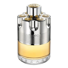 Product photography of the Azzaro Wanted perfume bottle with a distinctive silver and gold revolver cylinder top featuring gold bullet accents a textured silver band an amber liquid and the Azzaro logo engraved on the clear glass base