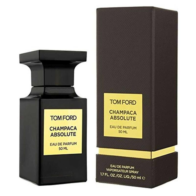 Photo of Tom Ford Champaca Absolute Eau de Parfum 50ml, featuring an elegant black glass bottle and a textured black rectangular box on a white background, both adorned with prominent gold labels detailing the scent and volume