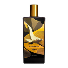 Memo Paris Ocean Leather Eau de Parfum bottle a dark rectangular vessel with a shimmering gold cap and a prominent stylized golden whale design amidst abstract gold wave patterns on a black label