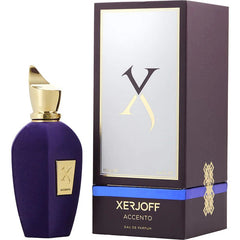Xerjoff Accento perfume bottle and box featuring a rich purple velvet-textured bottle with a gold sculptural cap and a dark brown box with a blue stripe and ornate gold X logo