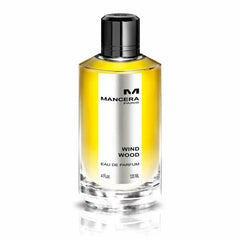 Product photograph by Mancera Paris featuring a clear glass bottle of Wind Wood Eau de Parfum with vibrant yellow liquid, a sleek black cap, and a prominent silver label