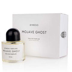 Byredo Mojave Ghost Eau de Parfum in a clear glass bottle with a black dome cap and its white minimalist packaging box showing 100 ML volume and a subtle geometric pattern on the side
