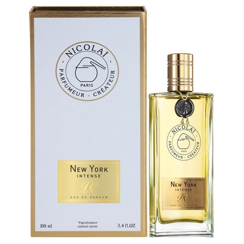 Nicolai New York Intense Eau de Parfum bottle and box, featuring a clear glass bottle with golden liquid, a ribbed gold cap, and a black wax seal tag, presented alongside its white box with gold trim and matching "New York Intense" branding and 100ml volume