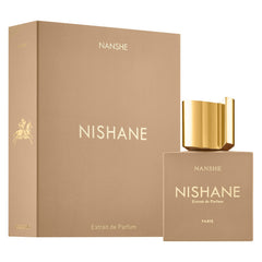 Product photography of a beige Nishane Nanshe Extrait de Parfum bottle and box with gold NISHANE and NANSHE text, a gold equestrian emblem, and a striking gold cap