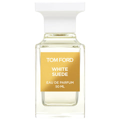 Tom Ford White Suede Eau de Parfum bottle featuring clear rectangular glass, a distinctive white fluted stopper, and a prominent amber-gold label displaying the product name and 50 ml volume in elegant white text