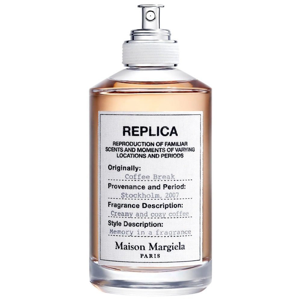 Maison Margiela Replica Coffee Break perfume bottle designed in Paris, featuring amber liquid in a clear glass bottle with a white typewritten label noting "Stockholm, 2007" provenance and a "creamy and cozy coffee" fragrance description, finished with a silver spray cap
