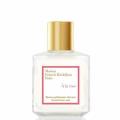 Maison Francis Kurkdjian Paris À la rose Scented hair mist, a clear rectangular glass bottle with a gleaming gold cap and a vibrant pink label displaying À la rose and Scented hair mist