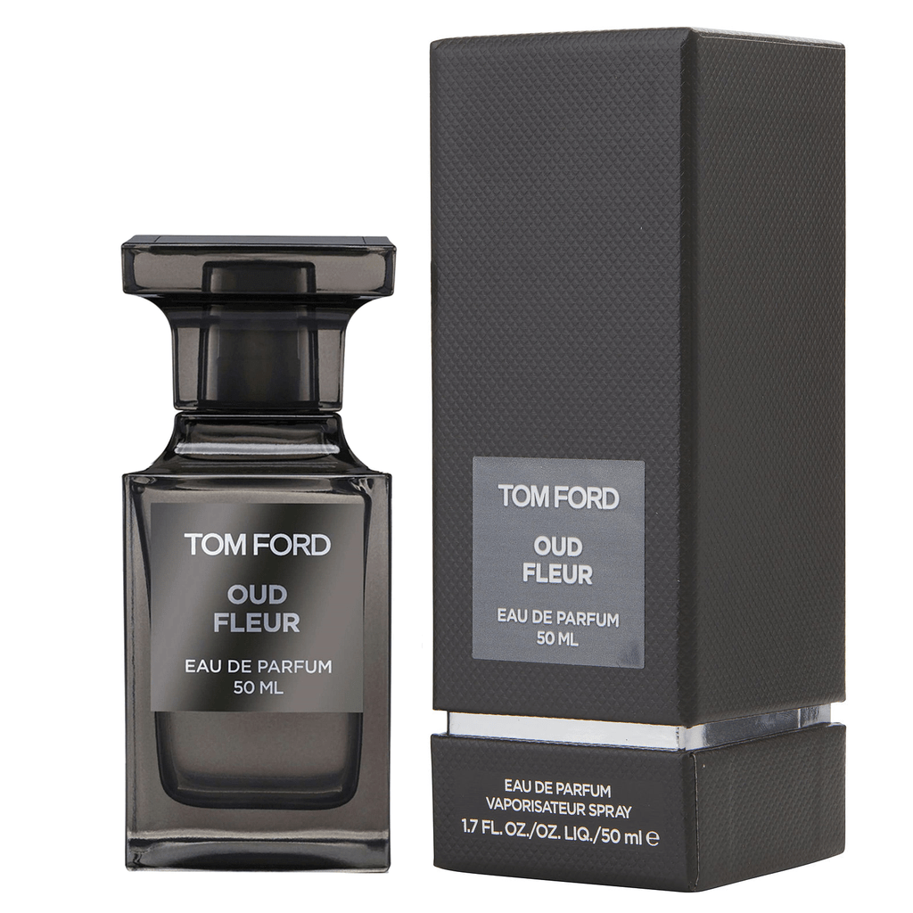 Product photography by Tom Ford depicting a dark grey translucent Oud Fleur Eau de Parfum bottle with a rectangular cap alongside its matching textured box on a clean white background