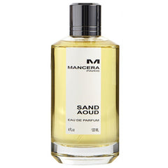 Photography of a Mancera Sand Aoud Eau de Parfum bottle featuring a clear glass base, light yellow liquid, a sleek black and silver cap, and a white label with "Mancera Paris" and "Sand Aoud" prominently displayed alongside the 120 ML volume
